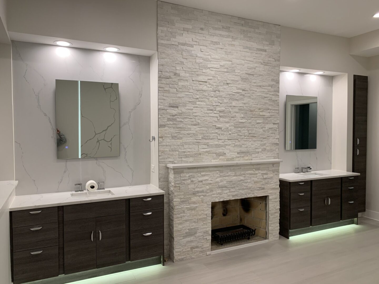 A modern bathroom with a fireplace and two sinks.