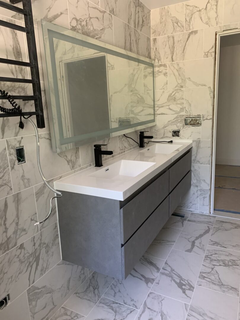 A bathroom with a marble floor and a mirror.