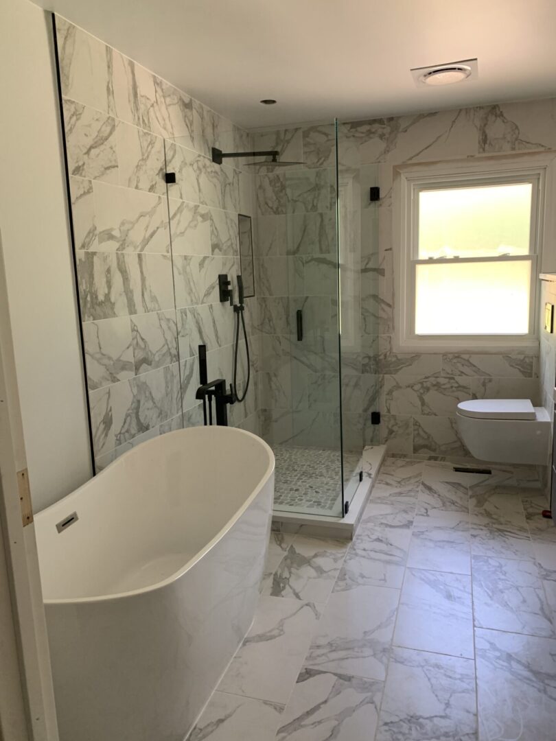 A marble bathroom with a tub and shower.