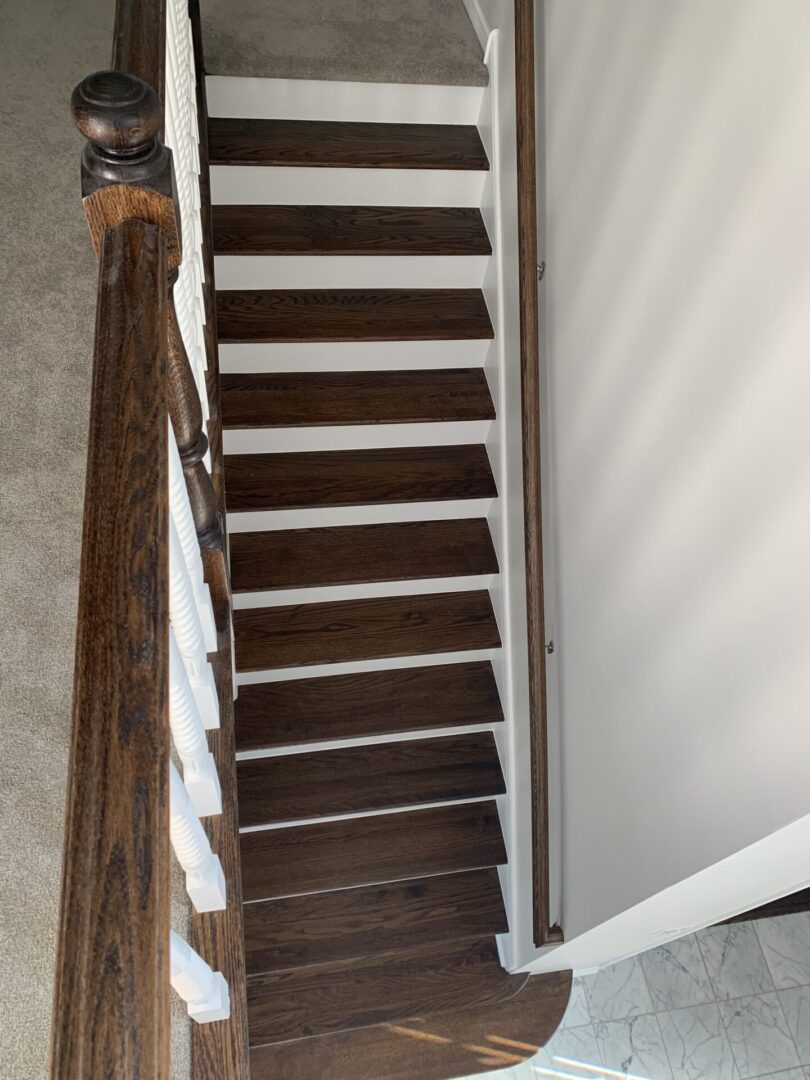 A staircase with wood treads and a white railing.