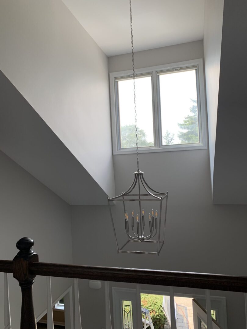 A stairway with a light fixture hanging above it.