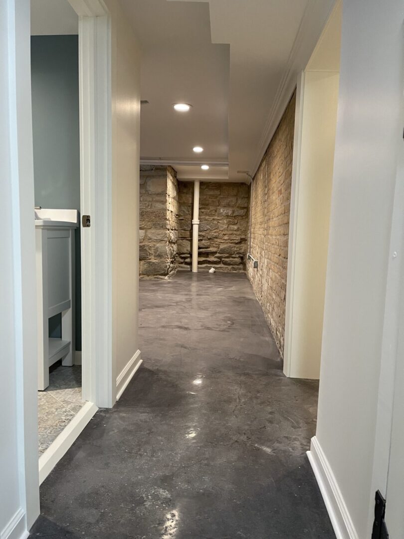 A hallway in a home with a concrete floor.