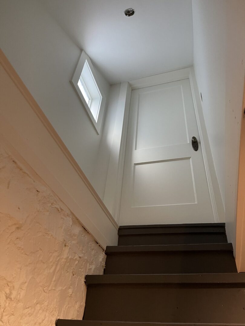 A stairway leading to a room with a white door.