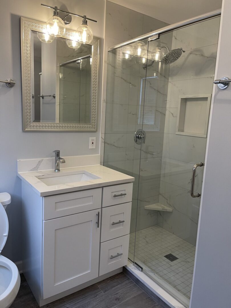 A white bathroom with a glass shower stall.