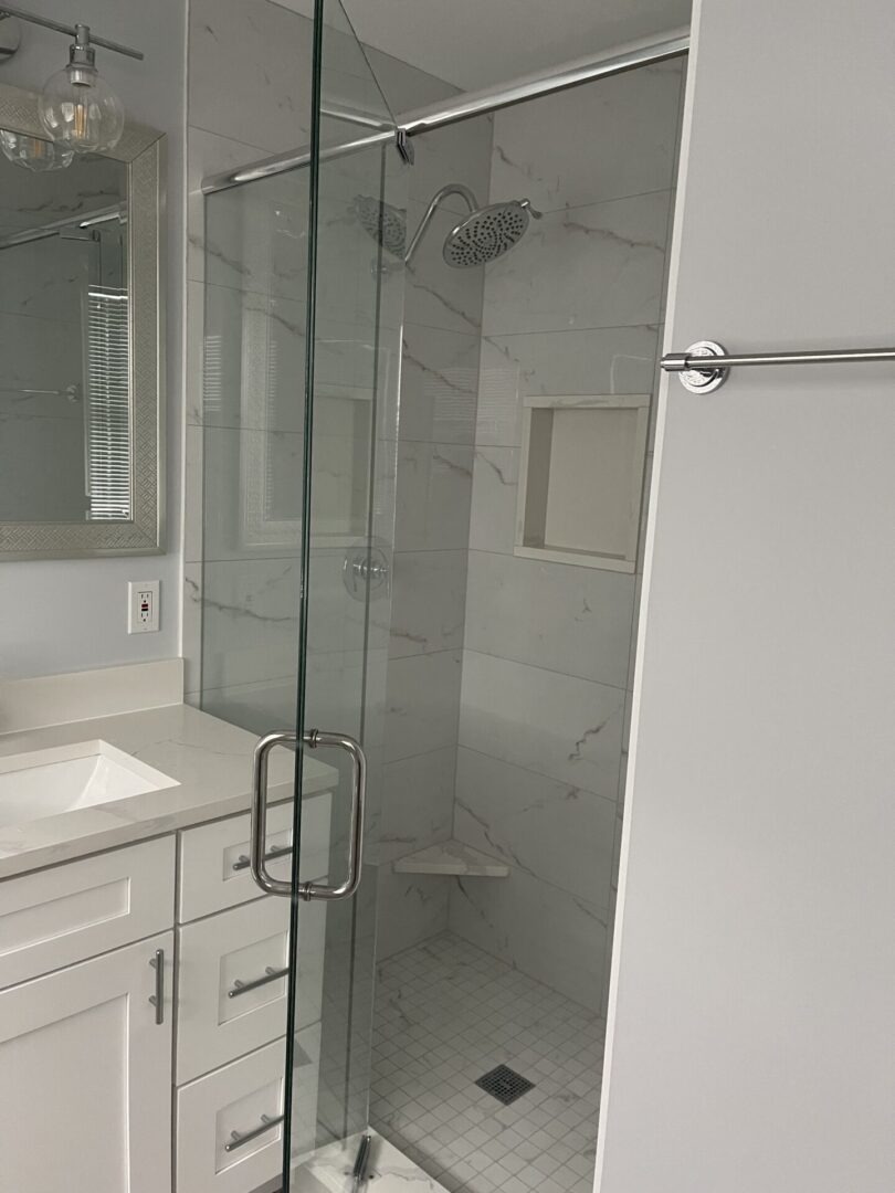 A white bathroom with a glass shower door.