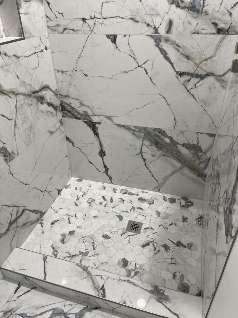 A bathroom with a white and black marble shower.
