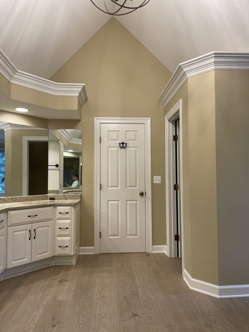A bathroom with white cabinets and a light fixture.