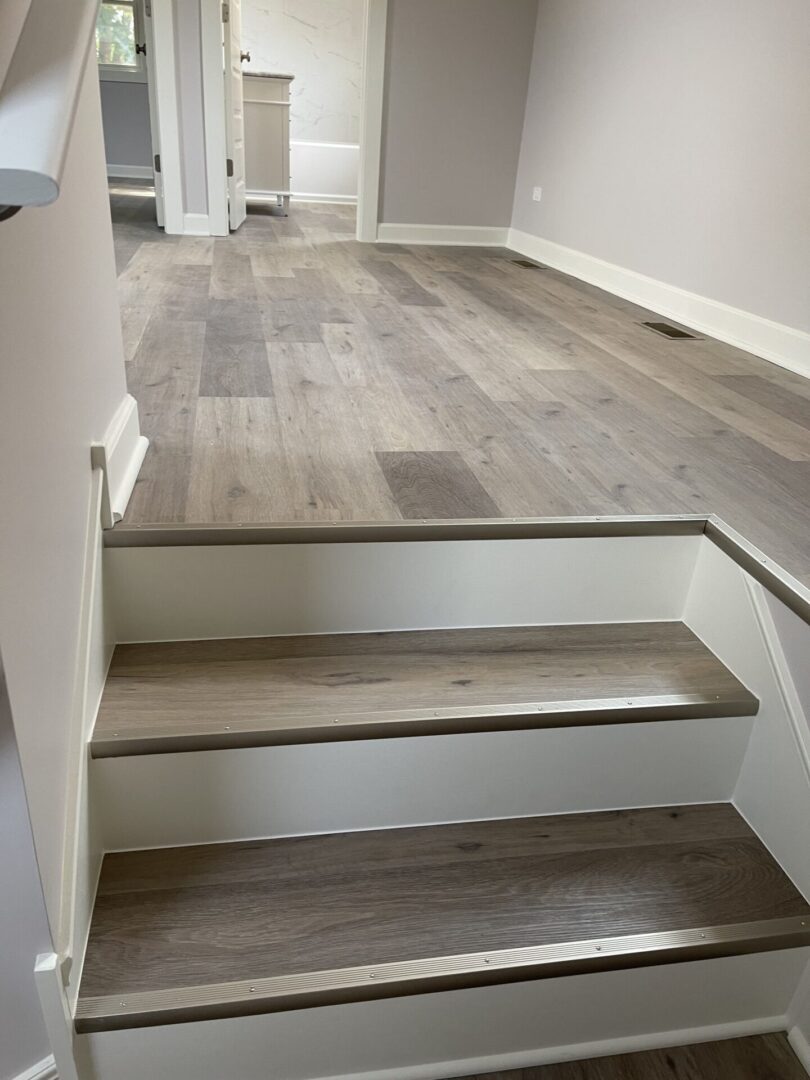A stairway with wood floors and white walls.