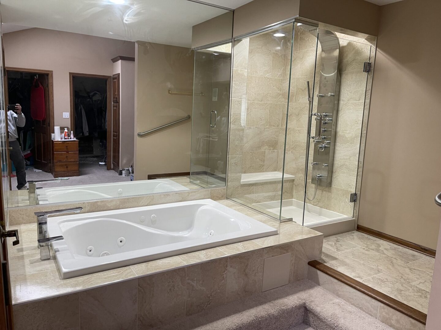 A bathroom with a glass shower enclosure and a jacuzzi tub.