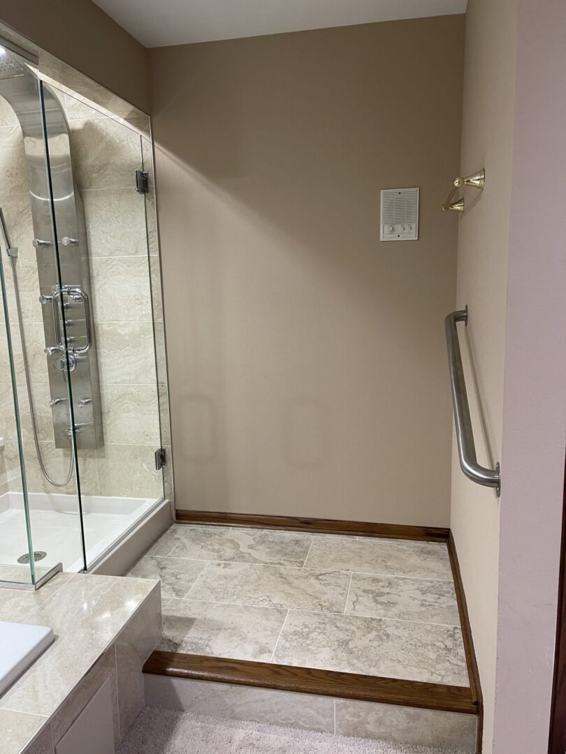 A bathroom with a walk in shower and glass door.