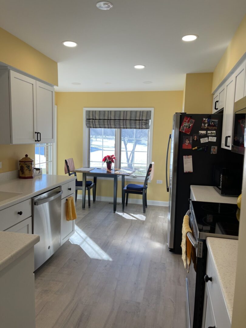 A kitchen with yellow walls and hardwood floors.