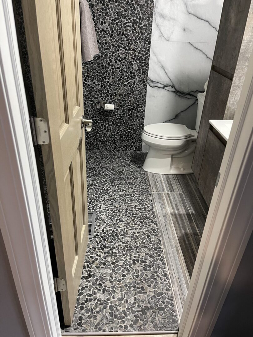 A bathroom with a black and white tile floor.