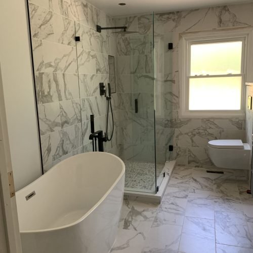 Modern bathroom remodel with bathtub, walk-in shower, and toilet featuring small tile walls and floor design