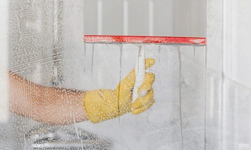 front view hand cleaning bathroom glass